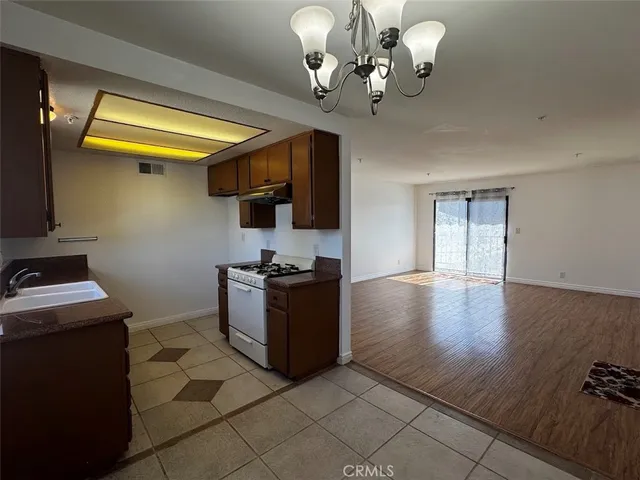 a kitchen with stainless steel appliances granite countertop a stove top oven a sink a counter space and cabinets