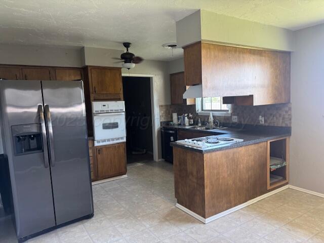 2121 Colgate Drive Perryton, TX 79070 - Photo 12 of 18 a kitchen with stainless steel appliances granite countertop a stove a refrigerator and a sink