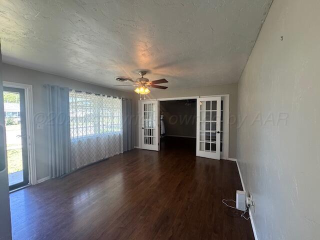 2121 Colgate Drive Perryton, TX 79070 - Photo 5 of 18 an empty room with wooden floor fireplace and windows