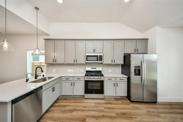 a kitchen with a sink stainless steel appliances and cabinets