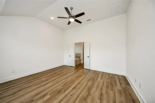 a view of a room with wooden floor and a ceiling fan