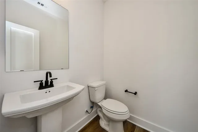 a bathroom with a sink a toilet and mirror