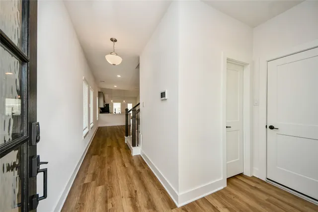 a view of a hallway with wooden floor and staircase
