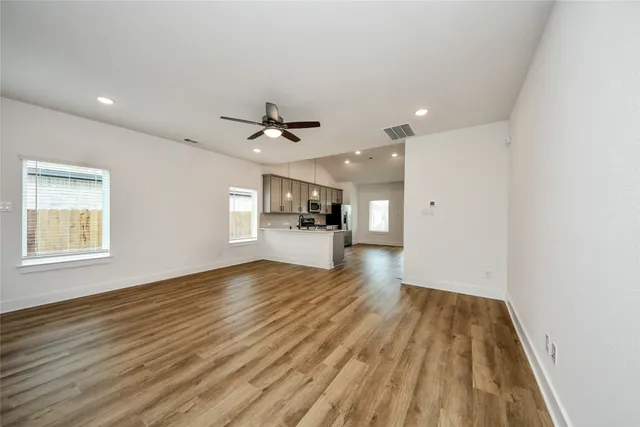 a view of empty room with wooden floor and window