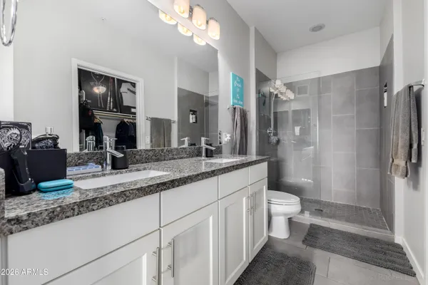 a bathroom with a double vanity sink toilet and shower