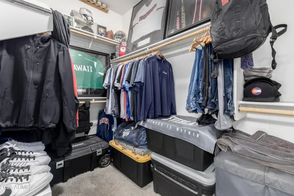 a view of walk in closet with clothes and shoes