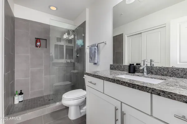 a bathroom with a granite countertop sink toilet and shower