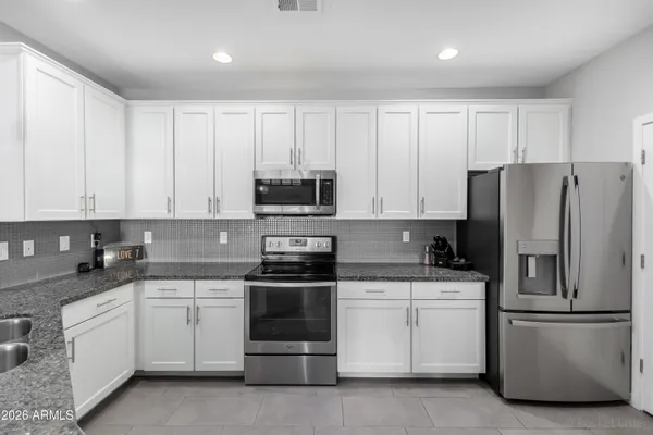 a kitchen with white cabinets and stainless steel appliances