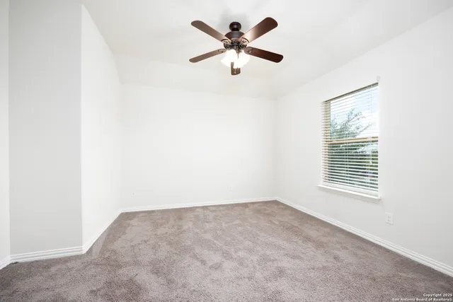 an empty room with a window and a fan