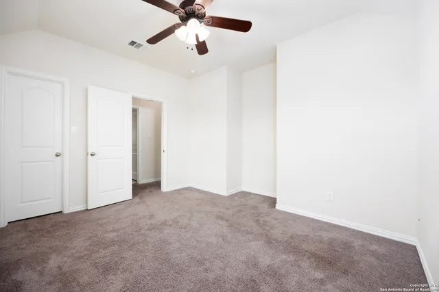an empty room with a window and a fan