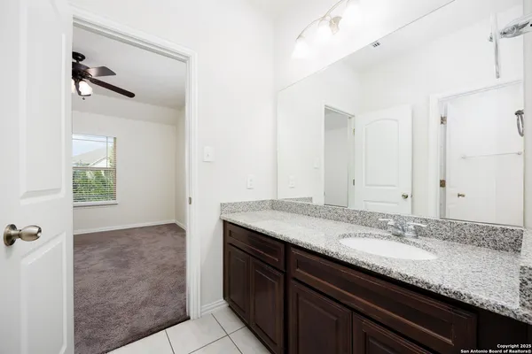 a bathroom with a granite countertop sink and a mirror