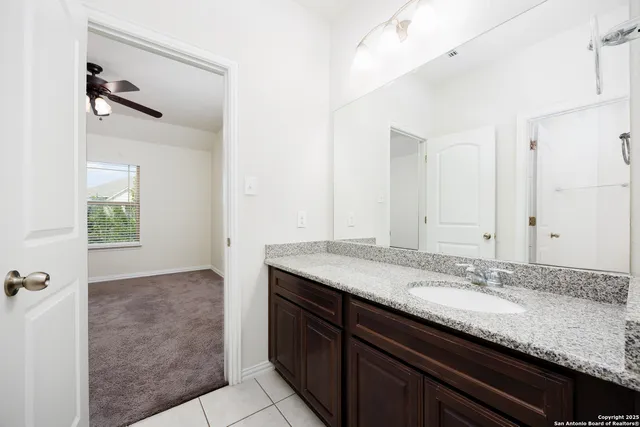 a bathroom with a granite countertop sink and a mirror