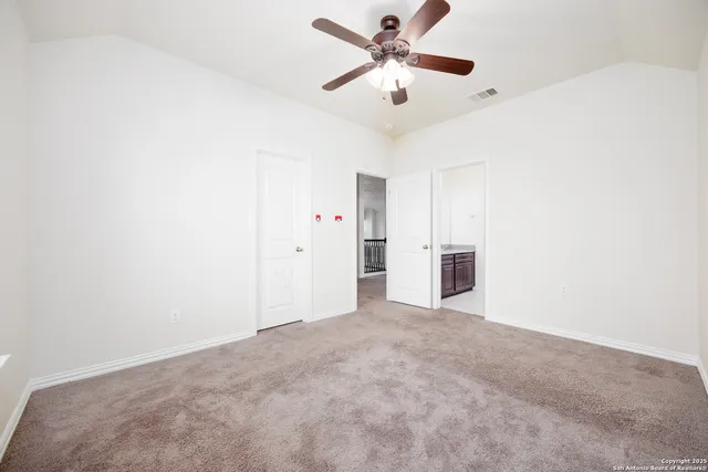 an empty room with a ceiling fan and a window