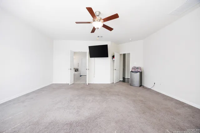an empty room with ceiling fan and window