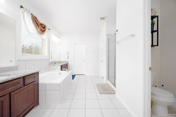 a spacious bathroom with a granite countertop sink a toilet and a bathtub