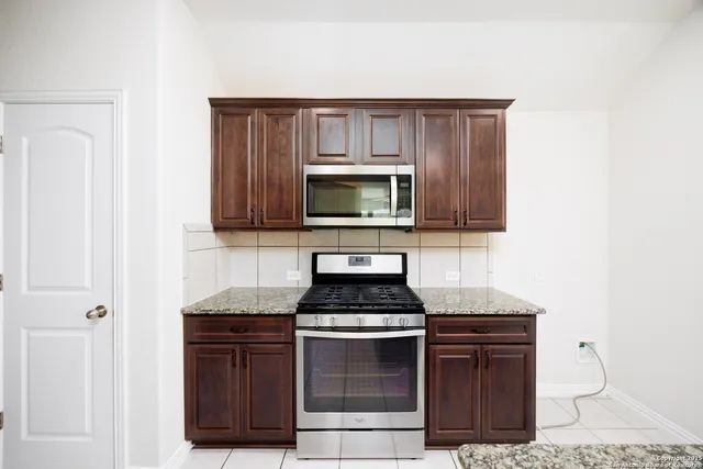 a kitchen with stainless steel appliances a stove and a microwave