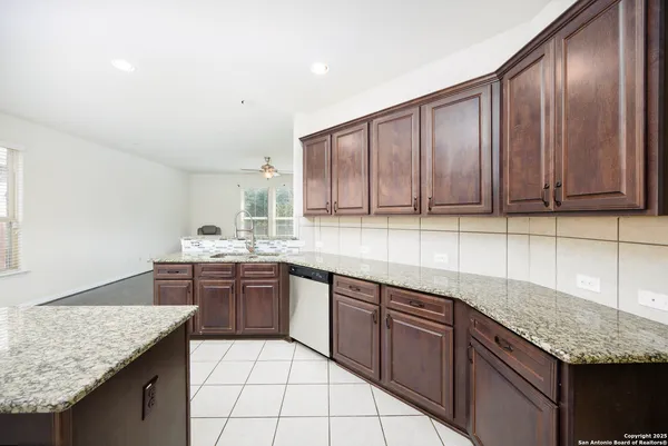 a kitchen with stainless steel appliances granite countertop wooden cabinets and granite counter tops