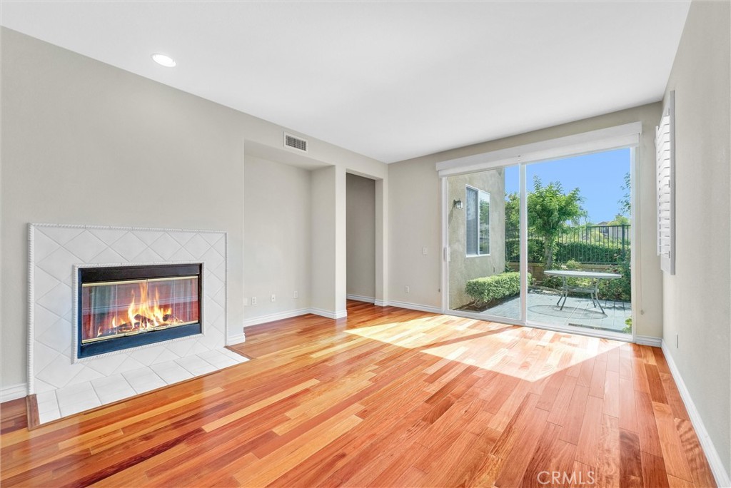 698 Legacy Drive Brea, CA 92821 - Photo 16 of 48 a view of an empty room with wooden floor and a fireplace