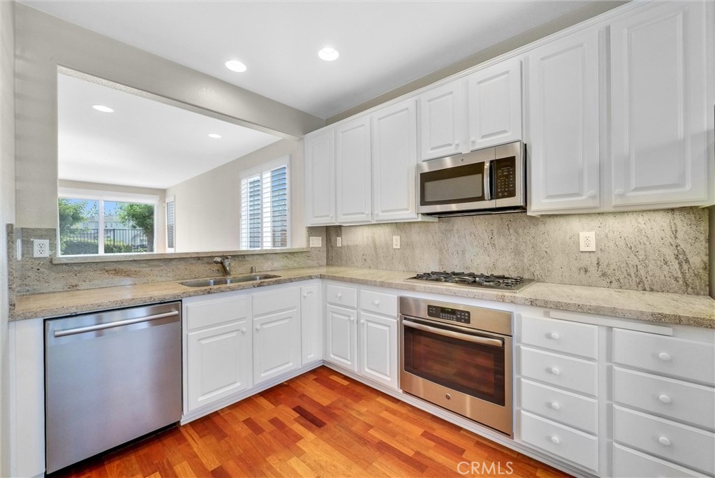 698 Legacy Drive Brea, CA 92821 - Photo 10 of 48 a kitchen with granite countertop white cabinets sink and stainless steel appliances