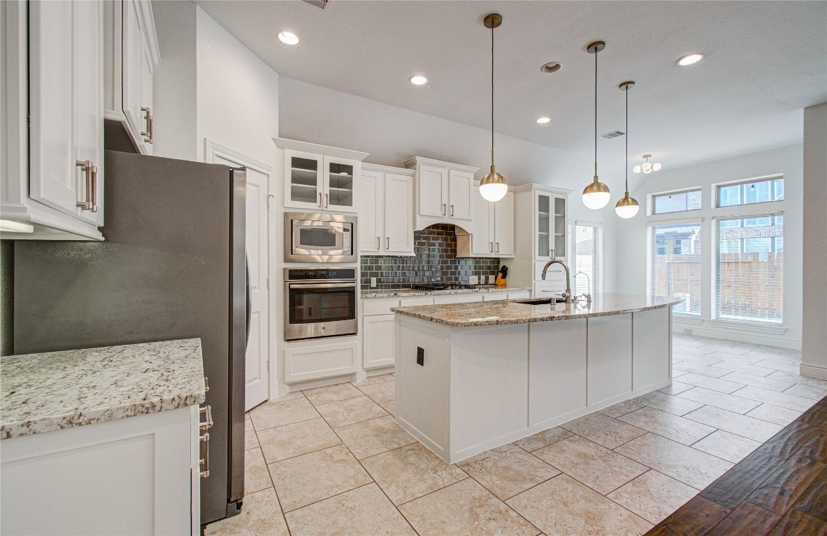 6614 Rising Hills Lane Sugar Land, TX 77479 - Photo 12 of 28 a kitchen with stainless steel appliances granite countertop a sink a stove and a refrigerator
