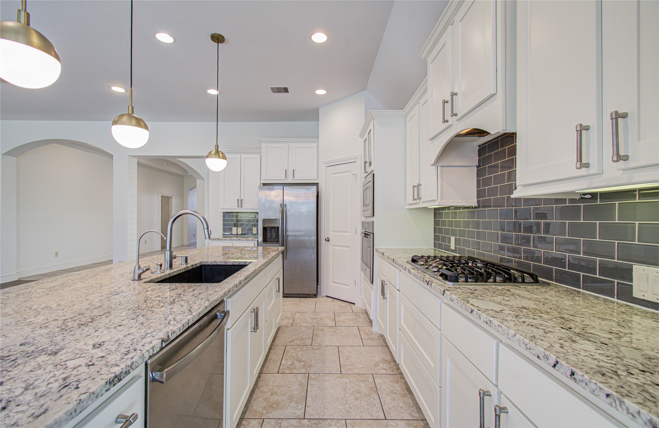 6614 Rising Hills Lane Sugar Land, TX 77479 - Photo 15 of 28 a kitchen with granite countertop stainless steel appliances a sink a stove top oven a counter space and cabinets
