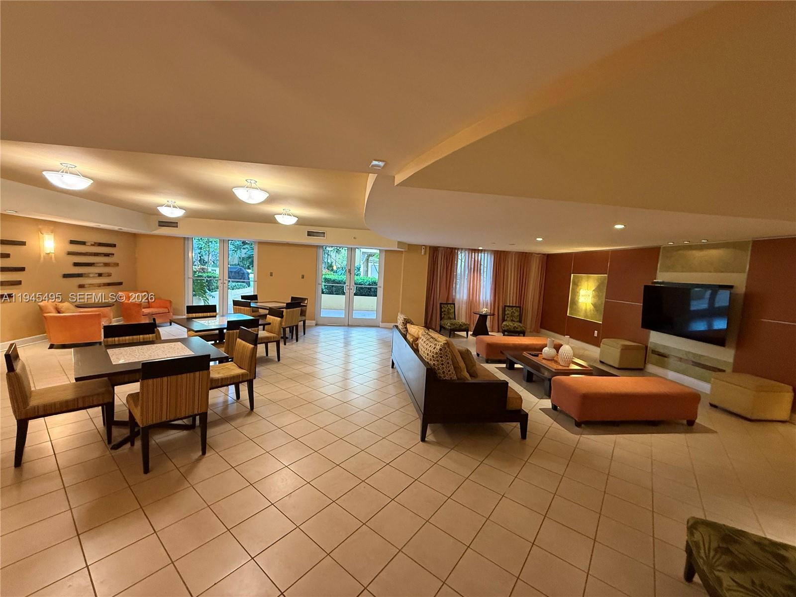 7350 Southwest 89th Street, Unit 1908S Miami, FL 33156 - Photo 23 of 28 a living room with furniture a flat screen tv and kitchen view