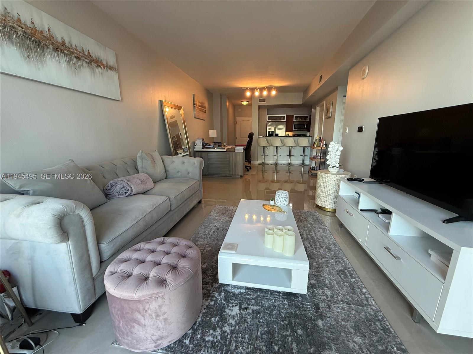 7350 Southwest 89th Street, Unit 1908S Miami, FL 33156 - Photo 6 of 28 a living room with furniture and a flat screen tv