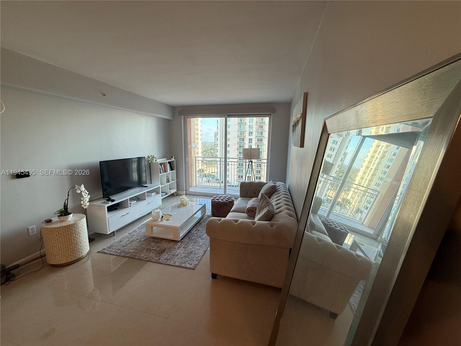 7350 Southwest 89th Street, Unit 1908S Miami, FL 33156 - Photo 7 of 28 a living room with furniture and a flat screen tv