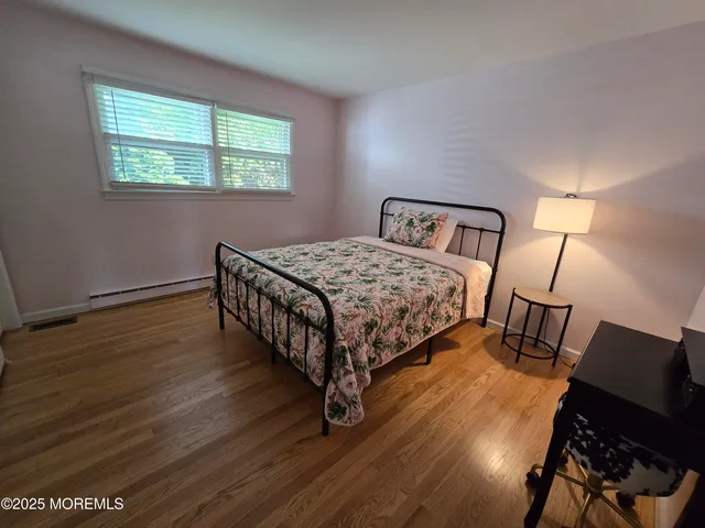 a bedroom with a bed a dresser and window