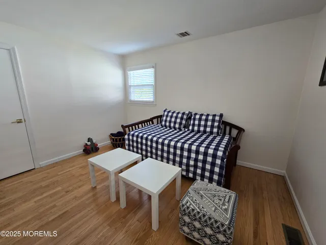a view of a bedroom with furniture and wooden floor