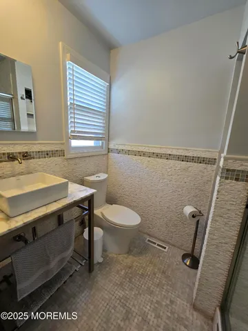 a bathroom with a sink a toilet and a mirror