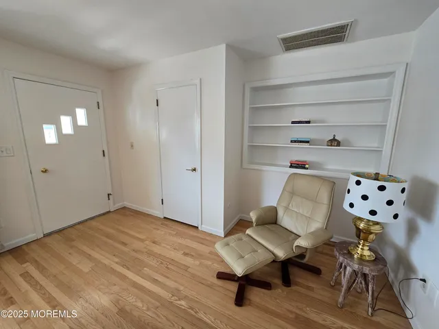 a view of a workspace with furniture and wooden floor