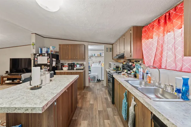 a kitchen with granite countertop a sink stove and cabinets