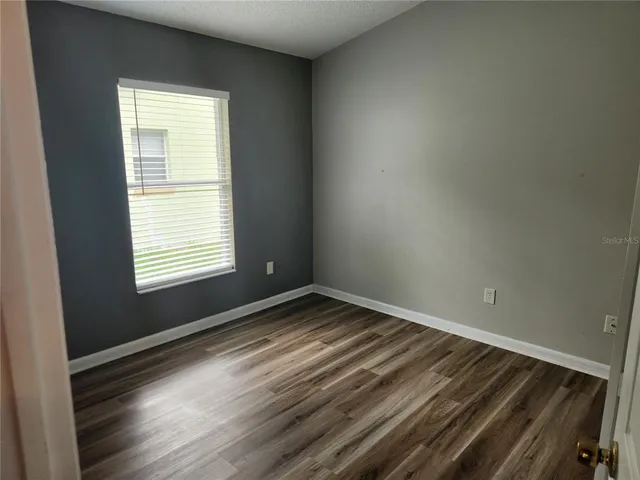 a view of a room with wooden floor and entryway