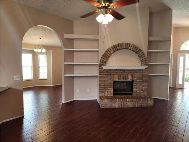 a view of a livingroom with furniture wooden floor fan and a fireplace