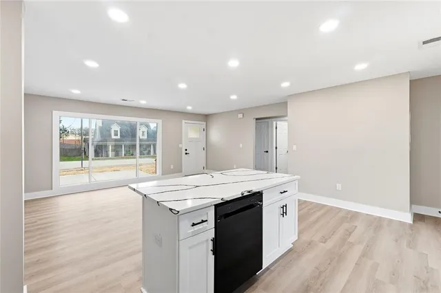 a room with a sink wooden floor and a window