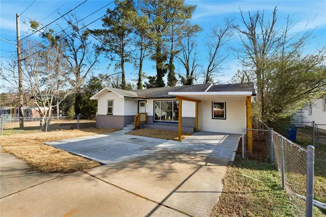 a view of a house with backyard and trees