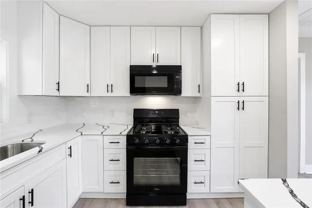 a kitchen with stainless steel appliances white cabinets and a stove a oven with white countertops