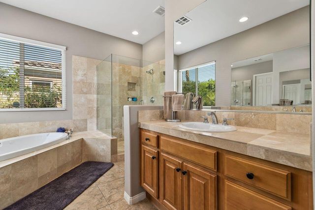 a bathroom with a granite countertop sink mirror bathtub and shower