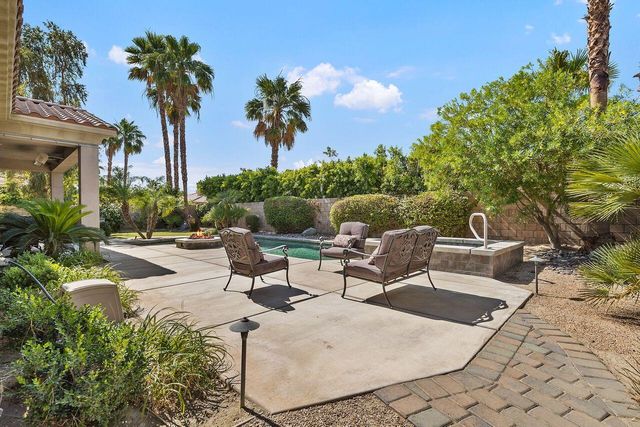 a view of a patio with couches table and chairs and potted plants
