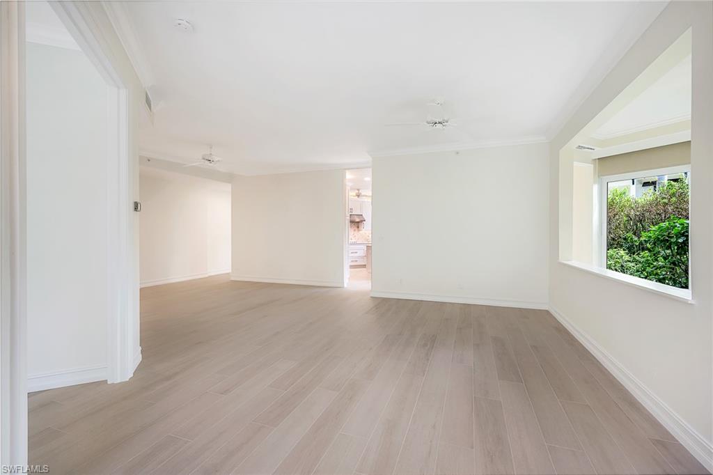 217 Colonade Circle Naples, FL 34103 - Photo 13 of 40 a view of an empty room with wooden floor and a window