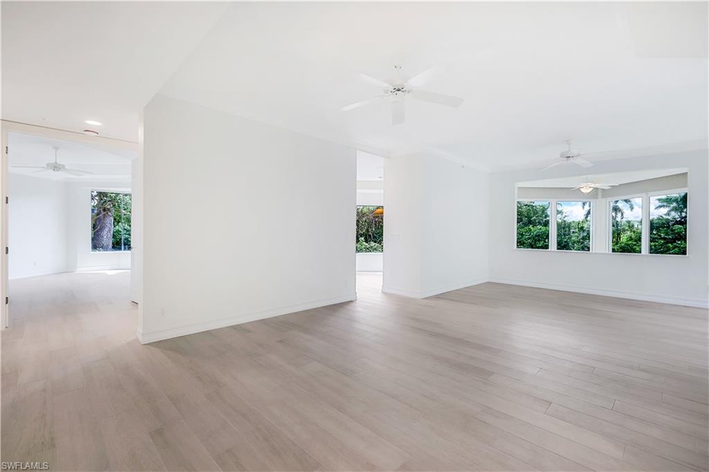 217 Colonade Circle Naples, FL 34103 - Photo 15 of 40 an empty room with wooden floor and windows