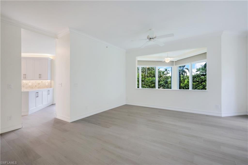 217 Colonade Circle Naples, FL 34103 - Photo 18 of 40 wooden floor in an empty room with a window