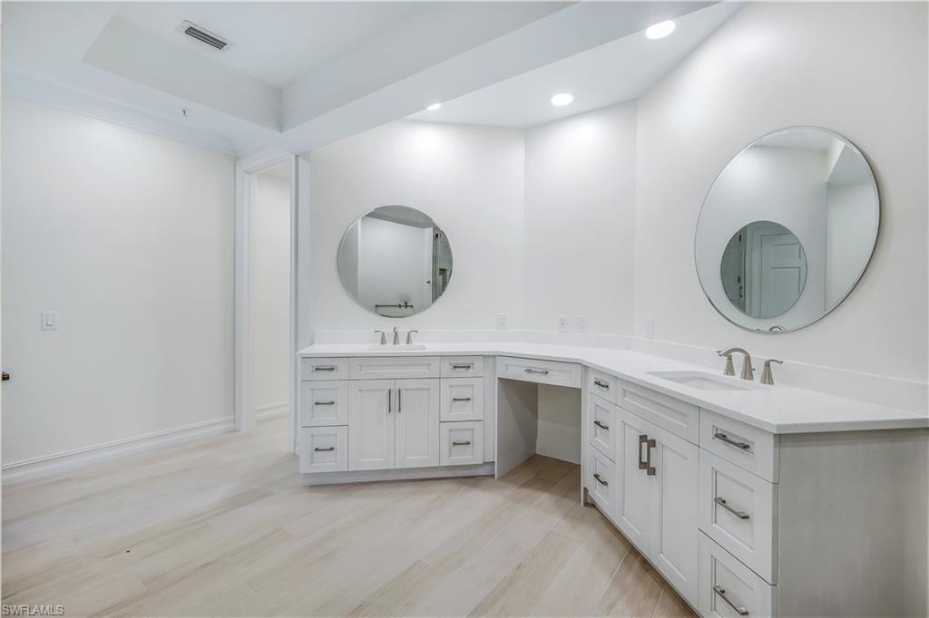 217 Colonade Circle Naples, FL 34103 - Photo 26 of 40 a bathroom with a double vanity sink and a mirror