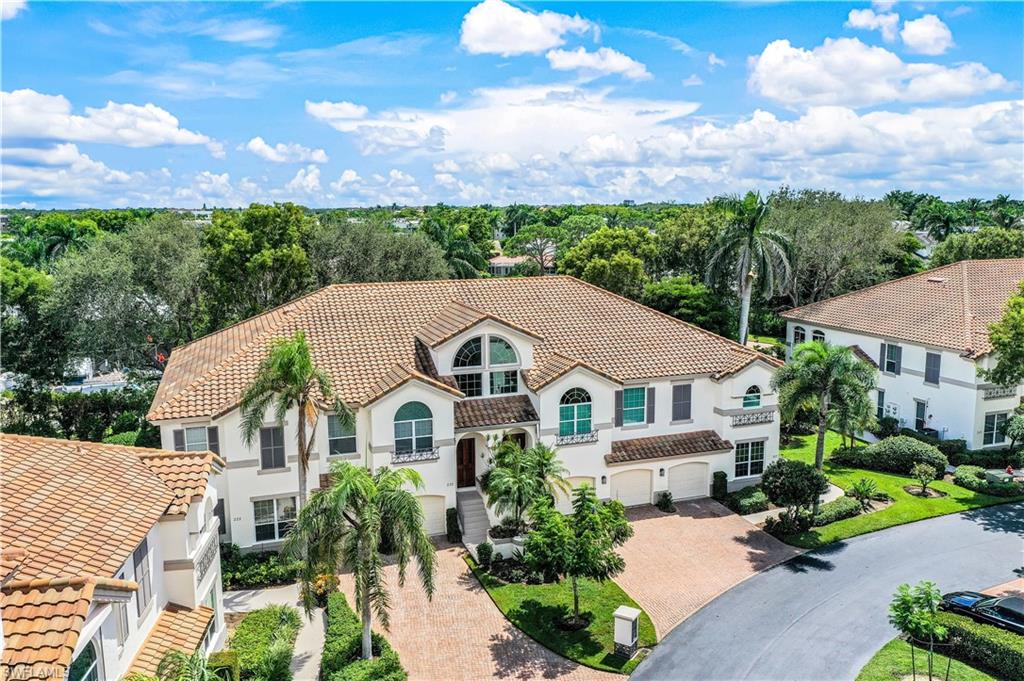 217 Colonade Circle Naples, FL 34103 - Photo 34 of 40 a view of a white house with a big yard plants and large tree