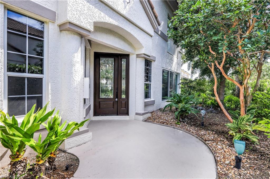 217 Colonade Circle Naples, FL 34103 - Photo 4 of 40 a front view of a house with a garden