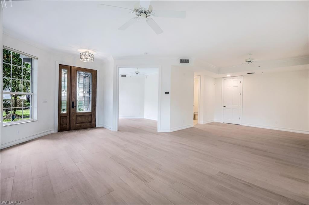217 Colonade Circle Naples, FL 34103 - Photo 5 of 40 an empty room with wooden floor and windows