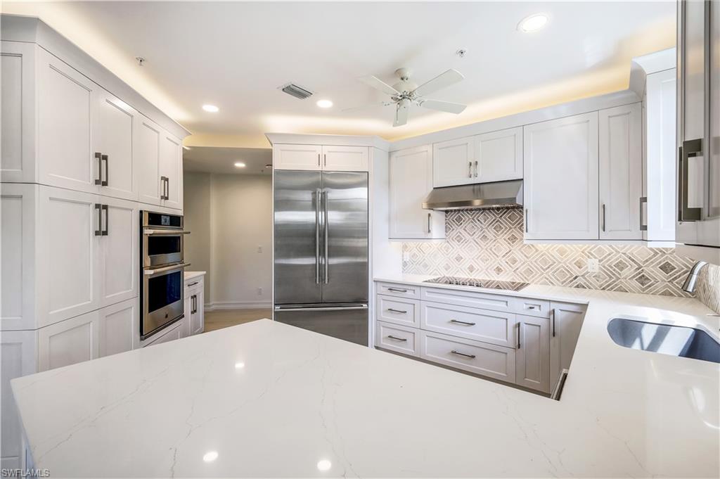 217 Colonade Circle Naples, FL 34103 - Photo 7 of 40 a kitchen with granite countertop a refrigerator and a sink