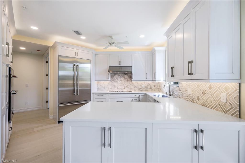 217 Colonade Circle Naples, FL 34103 - Photo 8 of 40 a kitchen with stainless steel appliances granite countertop a sink and cabinets