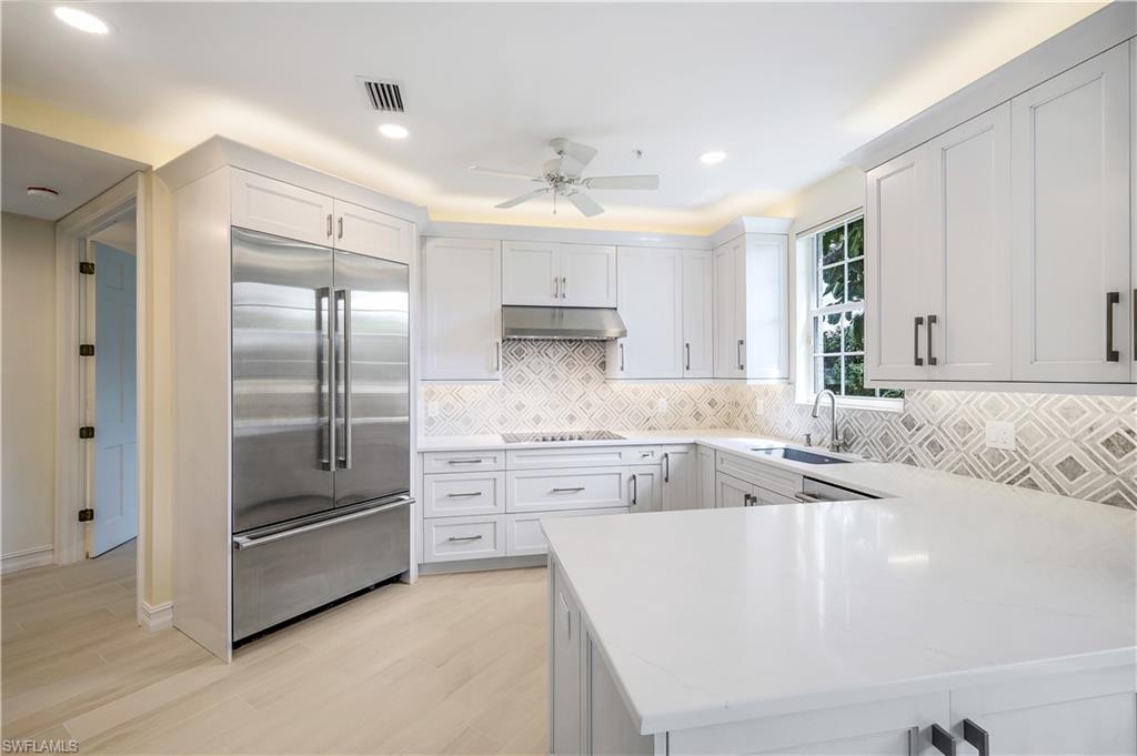 217 Colonade Circle Naples, FL 34103 - Photo 9 of 40 a large kitchen with kitchen island a stove a sink and a refrigerator